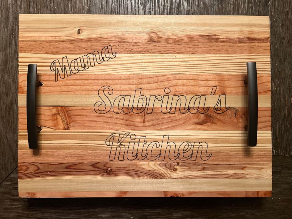 A wooden cutting board with handles on top of it.