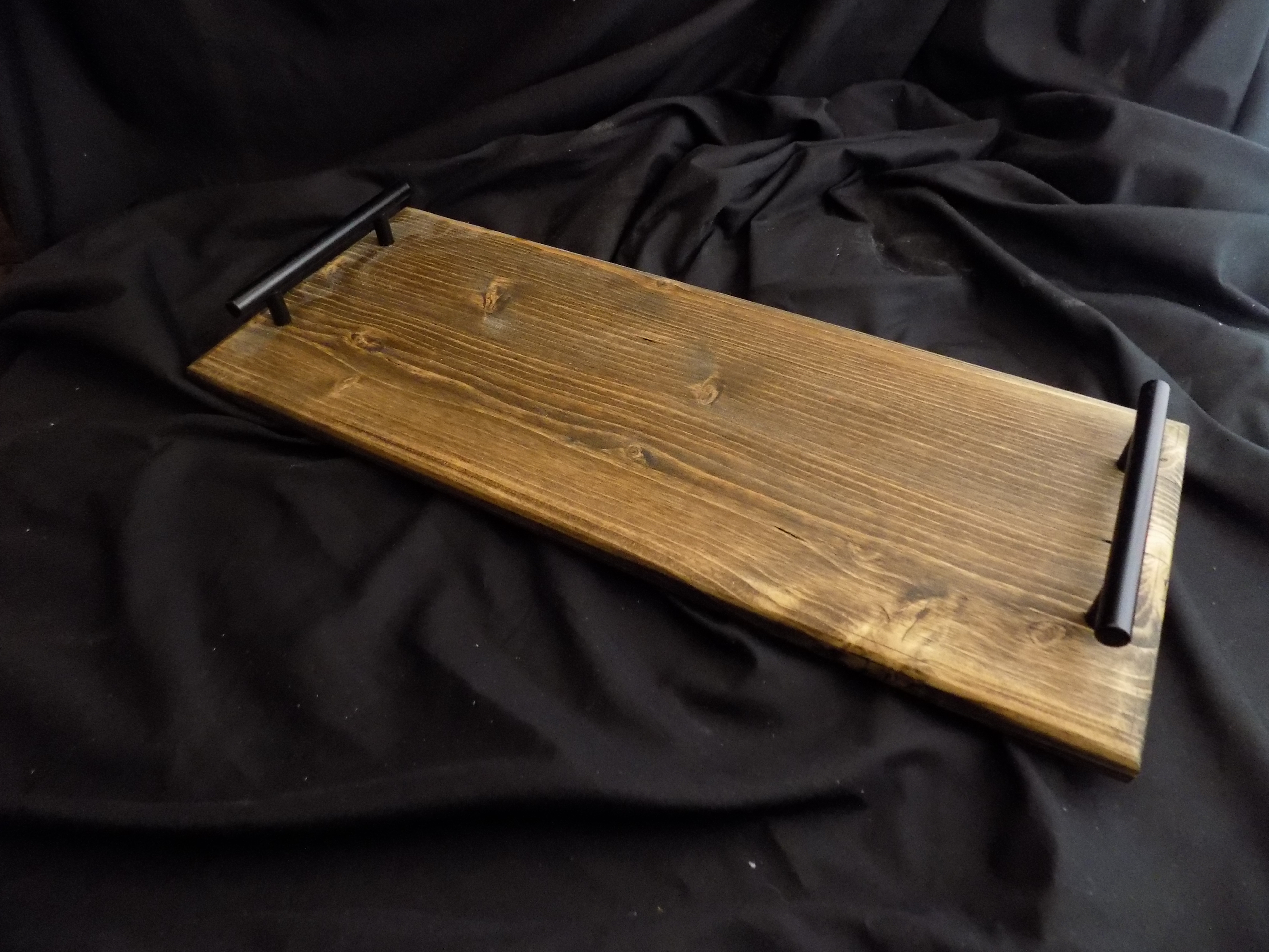 A wooden board with black handle on top of the table.