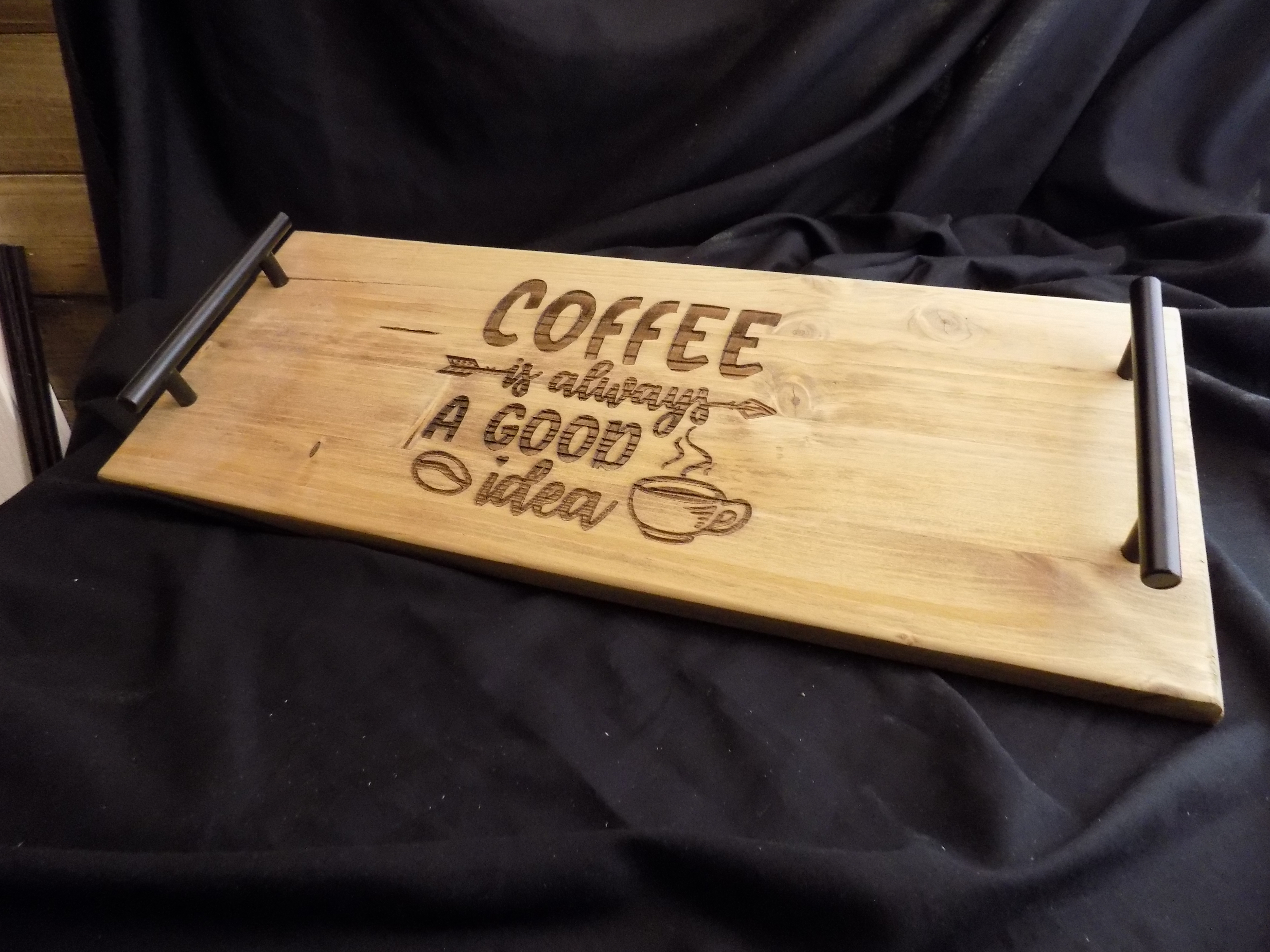 A wooden tray with coffee and quote engraved on it.