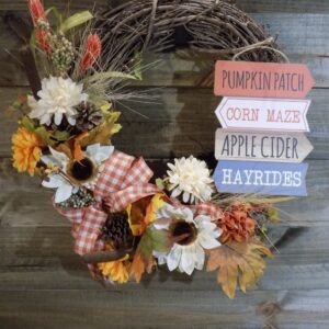 A wreath with autumn flowers and leaves on it.