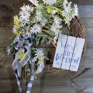 A wreath with flowers and a sign that says " we are blessed ".