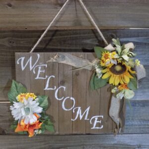 A wooden sign with flowers hanging on it.