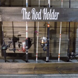 A wooden rack holding fishing rods and reels.